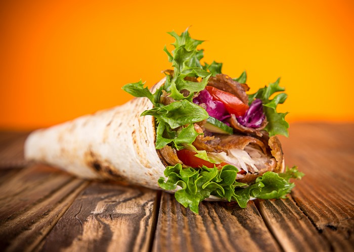 Kebab sandwich with vegetables on wood planks