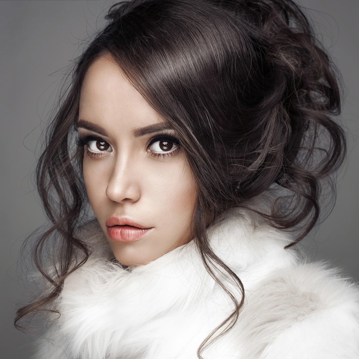 Woman with brown hair in white fur coat