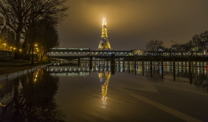 Eiffel Tower reflected in a river at night
