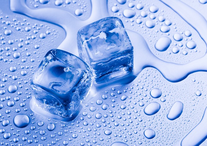 Ice cubes melting on a surface with water droplets