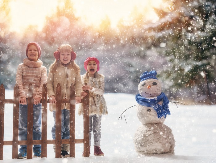 Children and Snowman in Winter Snowfall