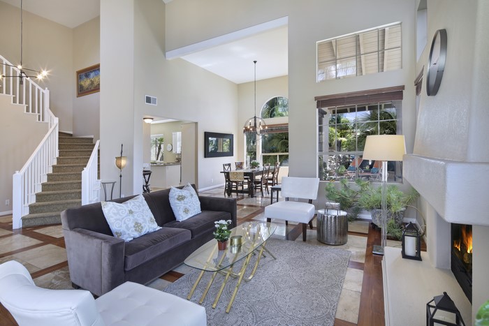 Living room with sofa, stairs, and dining area