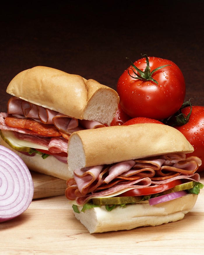 Two meat sandwiches with tomatoes and onion