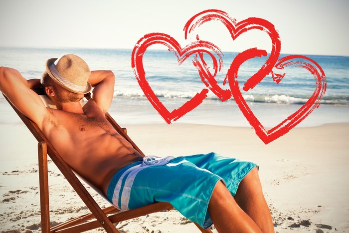 Man in Hat Relaxing on Beach with Hearts