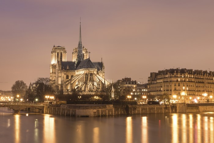 Notre Dame Cathedral at night in Paris over the Seine River