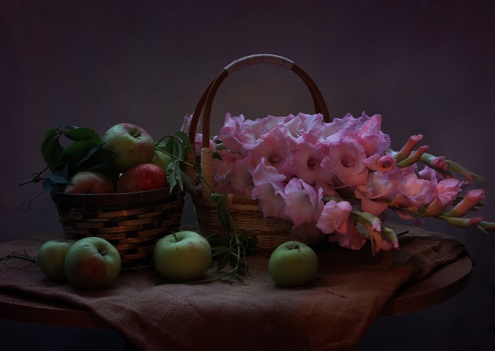 Still-life with apples and pink gladioluses in baskets