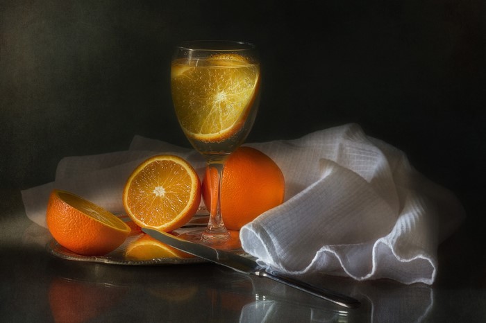 Still life with oranges and a glass of drink