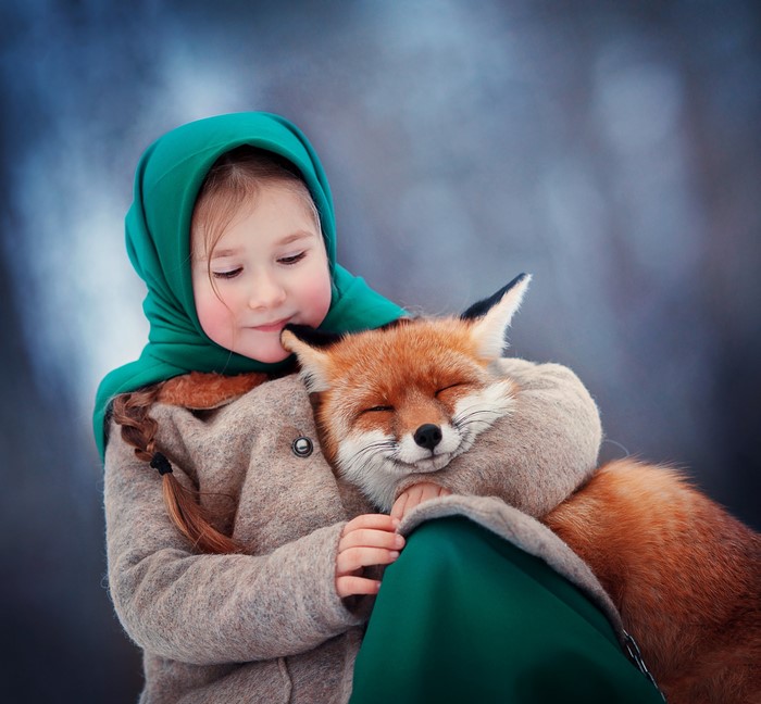 Girl hugging a fox in winter