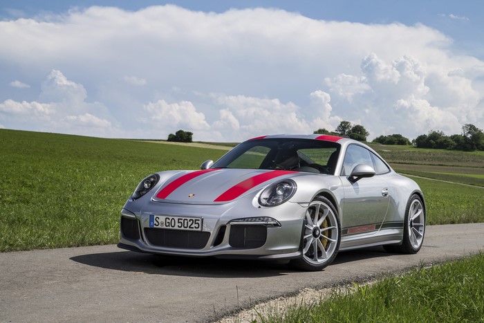 Porsche 911 R on a road with green fields