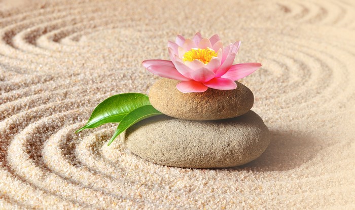 Zen garden with stacked stones and pink water lily