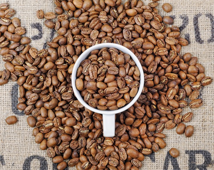 Coffee beans in a cup on burlap