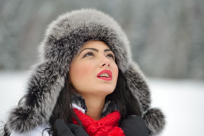 Woman in fur hat and red scarf in winter