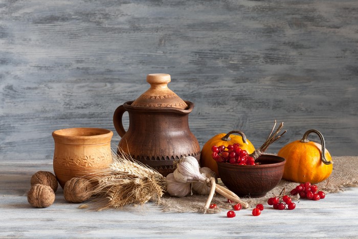 Still life with pumpkins, garlic, nuts, and pottery