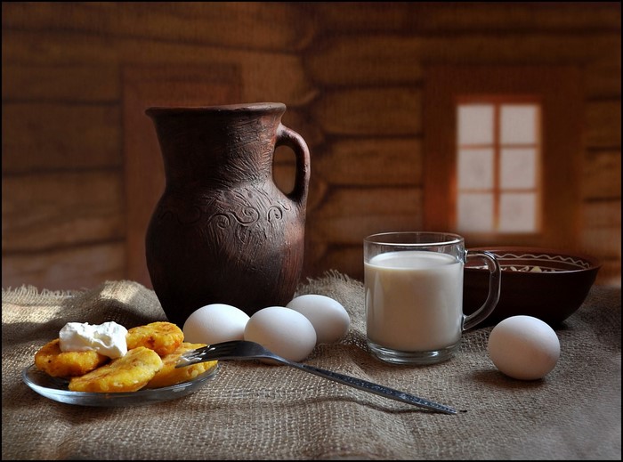 Still-life with pancakes, eggs, milk, and a jug