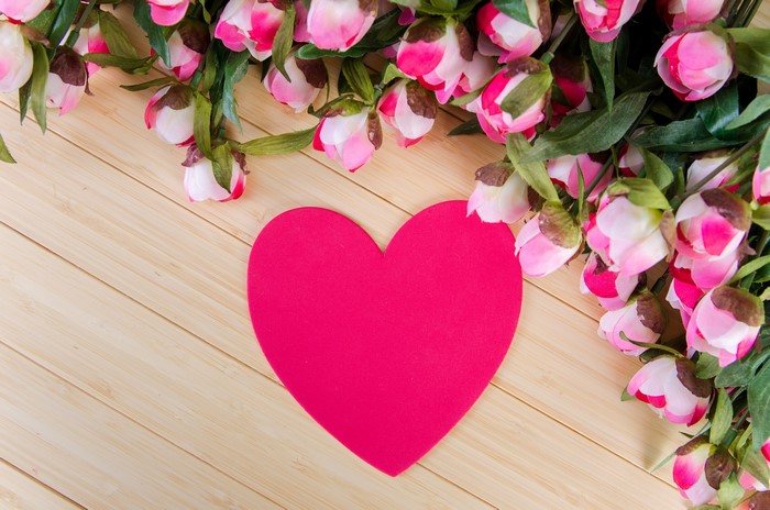 Pink roses and heart on wood planks