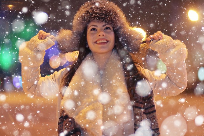 Woman in fur hat and scarf in snow