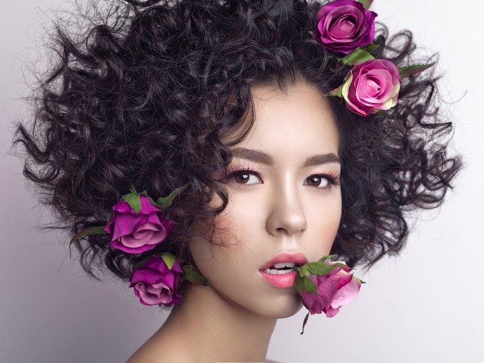 Woman with curly hair and roses