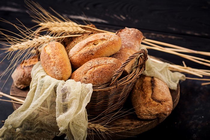 Bread in a wicker basket with wheat ears