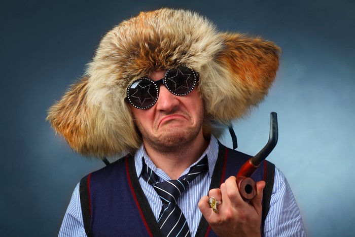Man in fur hat and star glasses holding pipe