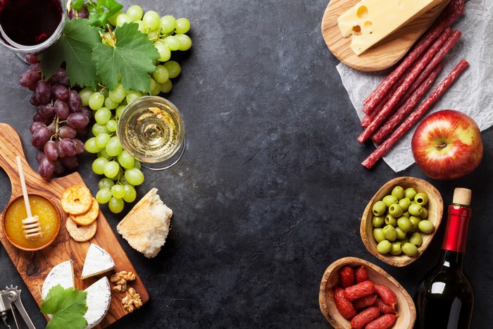 Grapes, Cheese, Sausage, Wine, and Fruit Platter