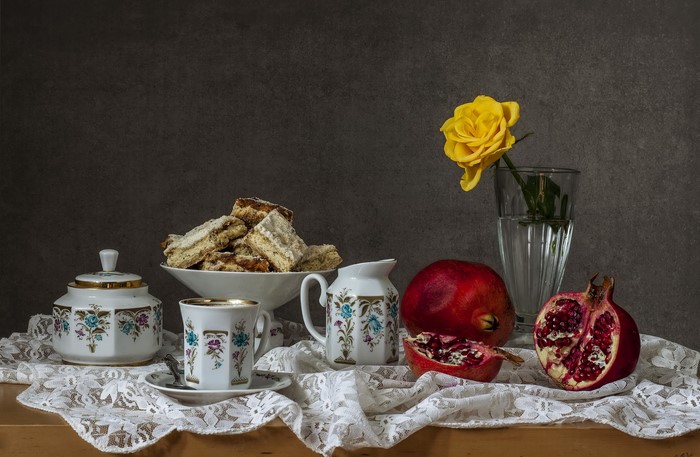 Still-life with pastries, pomegranate, and a yellow rose