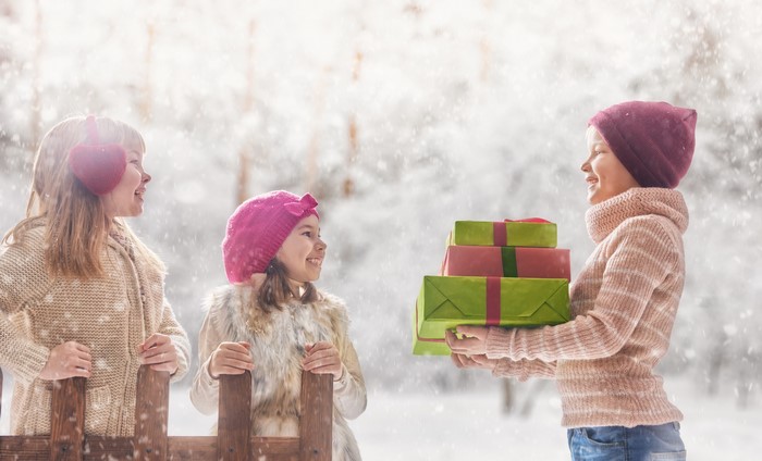 Three girls with gifts in winter