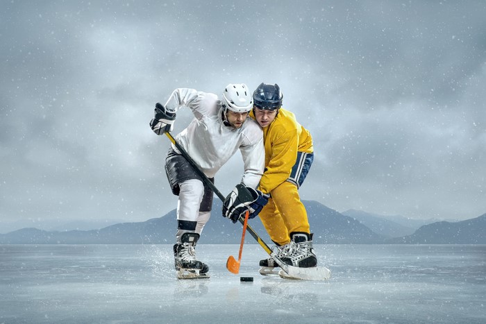 Two hockey players in uniform on ice