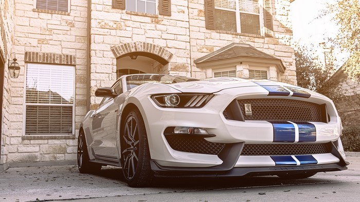 White Ford Mustang GT350 in front of a house
