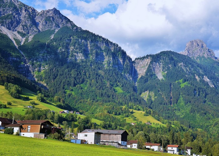 Houses in a valley with mountains and forests in Austria