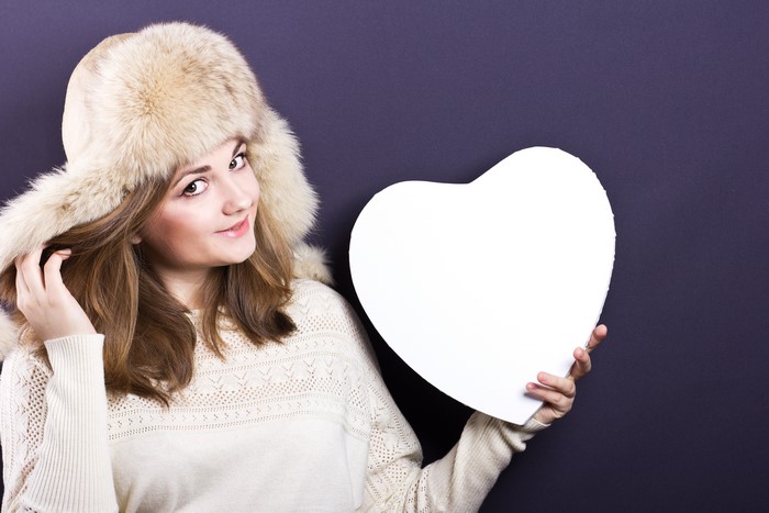 Woman in Winter Hat Holding White Heart