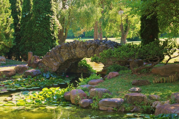 Stone bridge over a pond with lily pads at Sonnenburg Gardens