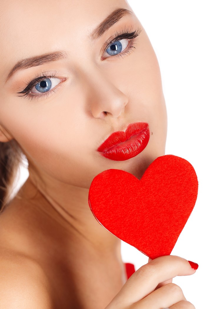 Woman with red lips holding a red heart