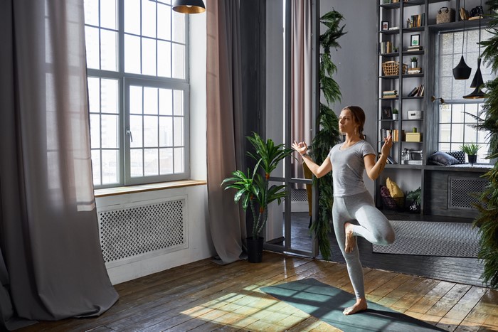 Woman doing yoga in a sunlit room