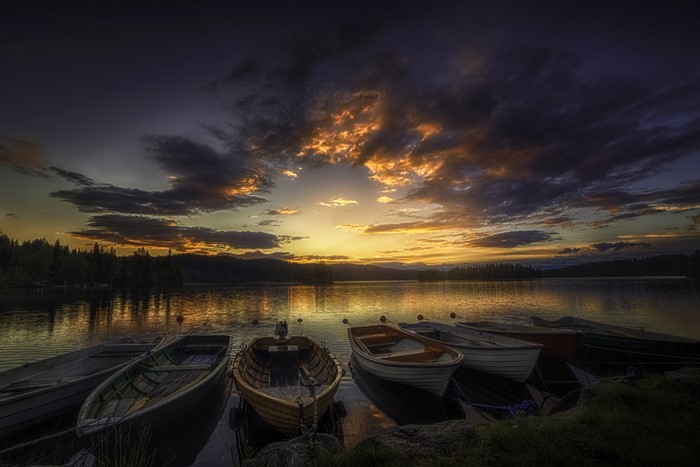 Boats on a lake at sunset with dramatic clouds