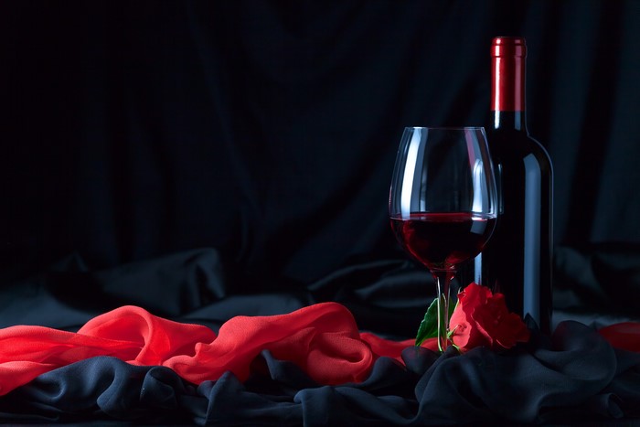 Wine bottle and glass with red rose