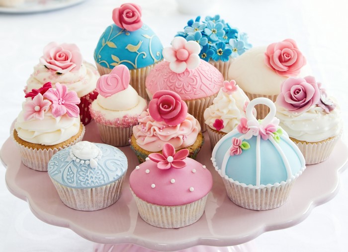Assortment of decorated cupcakes on a pink cake stand