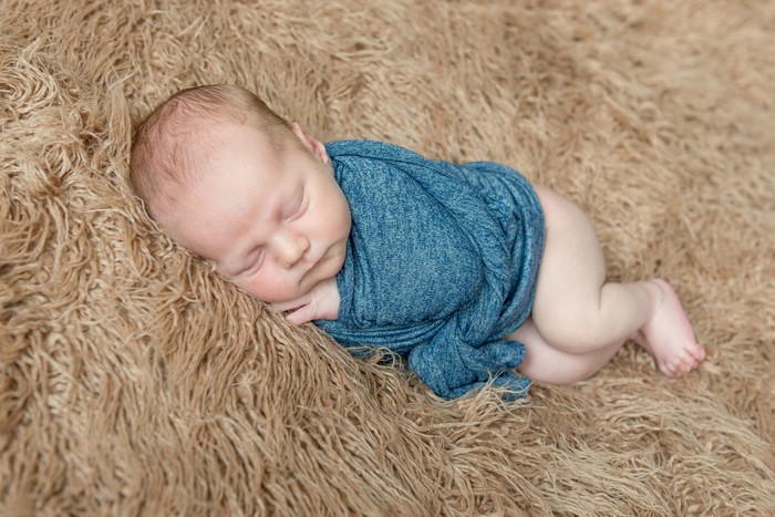 Newborn baby sleeping on a fluffy blanket