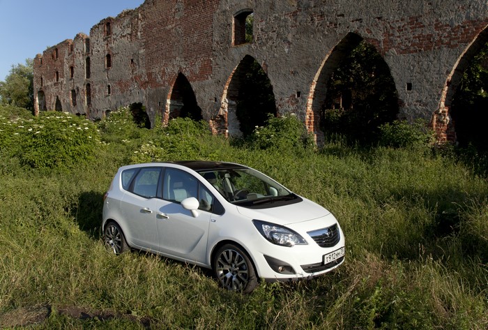 White Opel Meriva in front of ruins