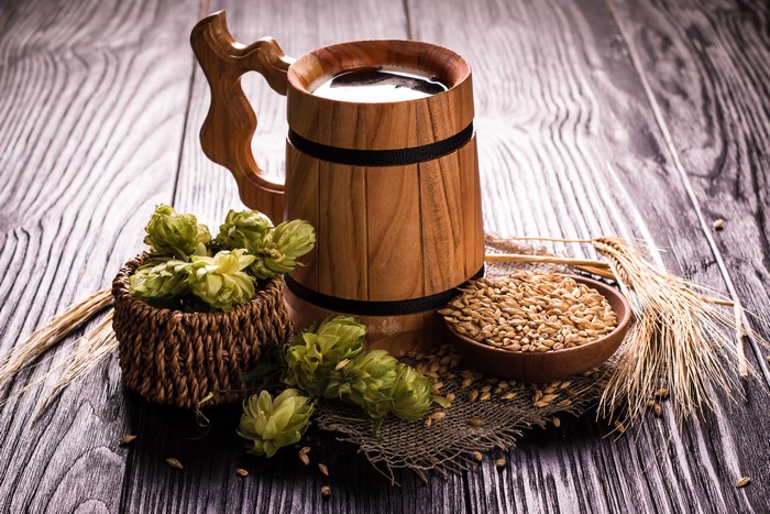Beer mug with hops and grain on wood planks