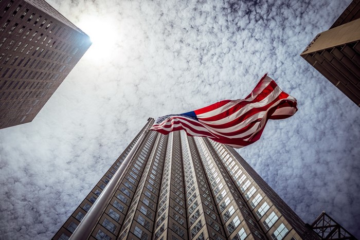 American Flag Waving Between Skyscrapers