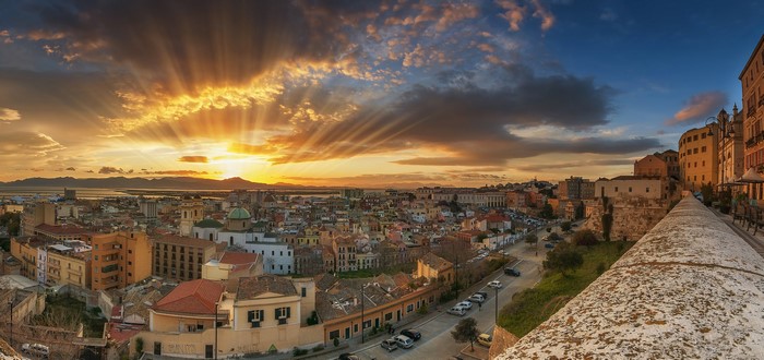 Cagliari, Italy cityscape at sunset with sun rays