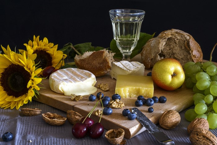 Still-life with cheese, fruit, nuts, and sunflowers