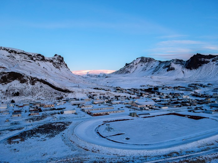 Snowy village nestled between mountains in Iceland