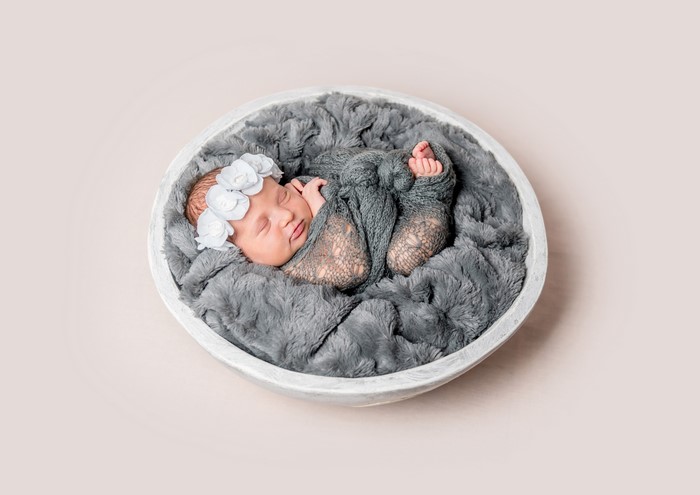 Newborn baby sleeping in a bowl