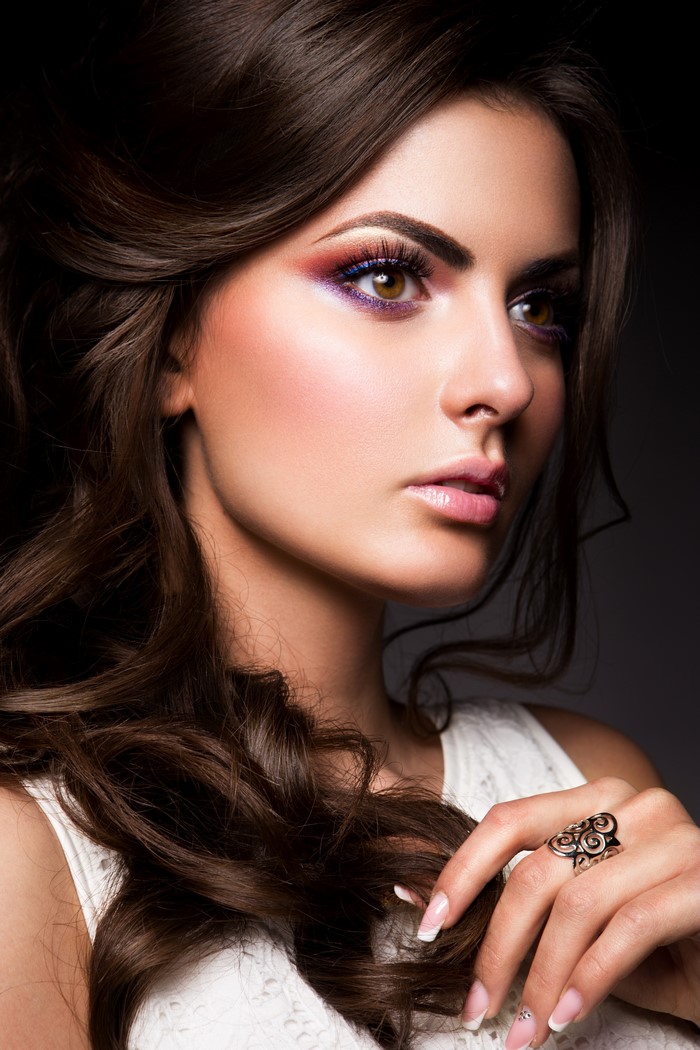Woman with brown hair and colorful makeup