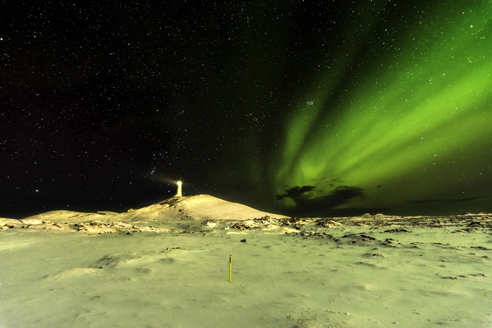 Lighthouse under Aurora Borealis in Iceland