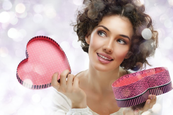 Woman holding heart-shaped gift boxes