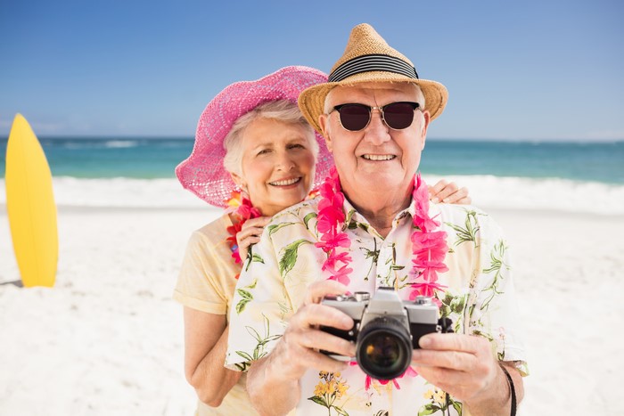 Elderly Couple with Camera on Beach