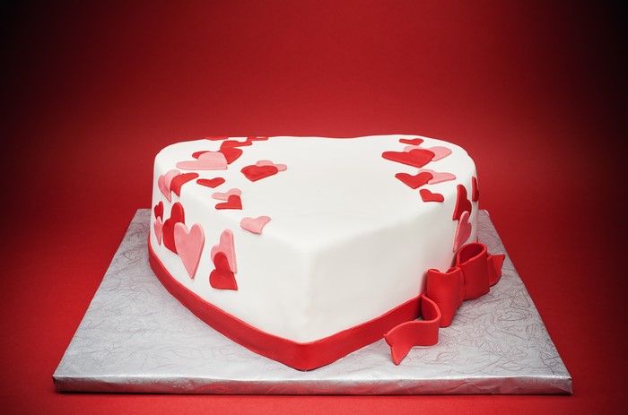 Heart-shaped cake with red hearts and bow