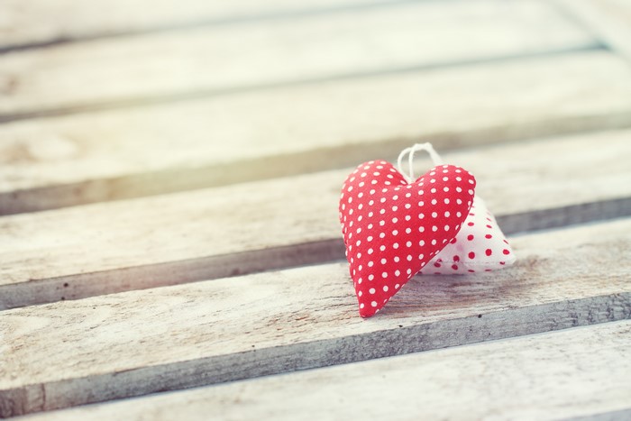 Two heart-shaped ornaments on wood planks